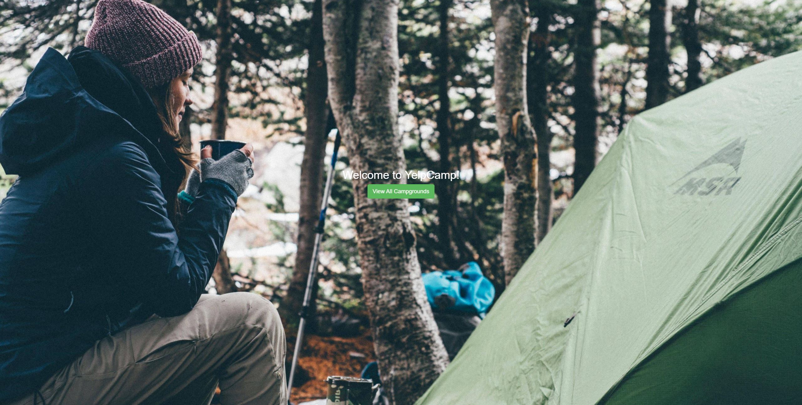 print screen of a lady sitting by a tent in the woods